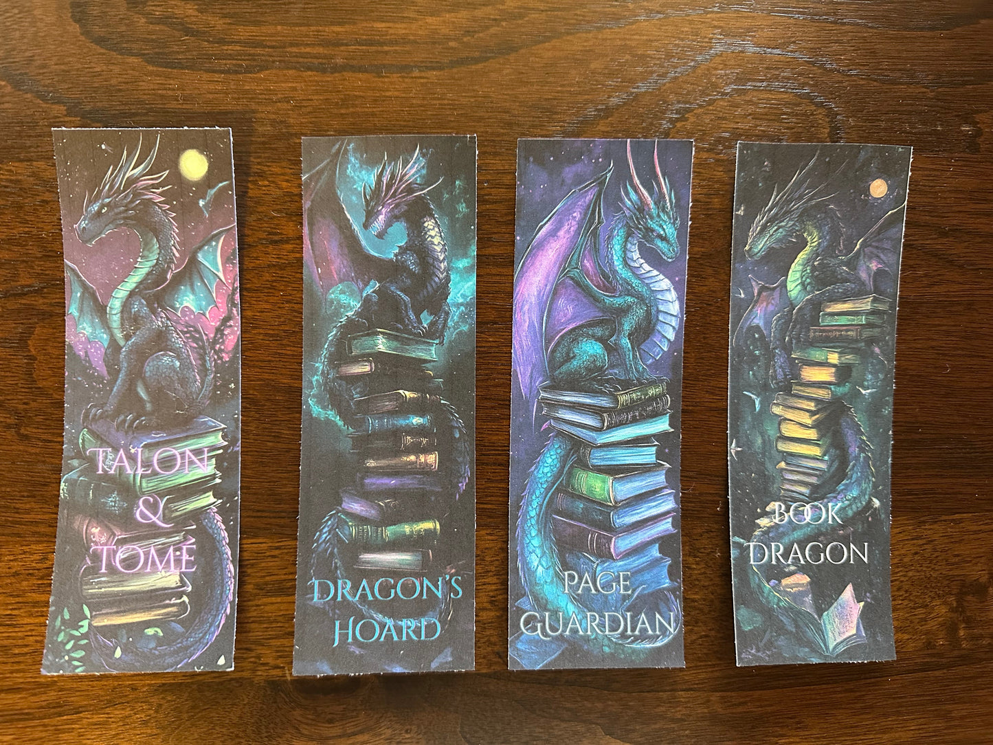 Four dragon-themed bookmarks on a wooden surface